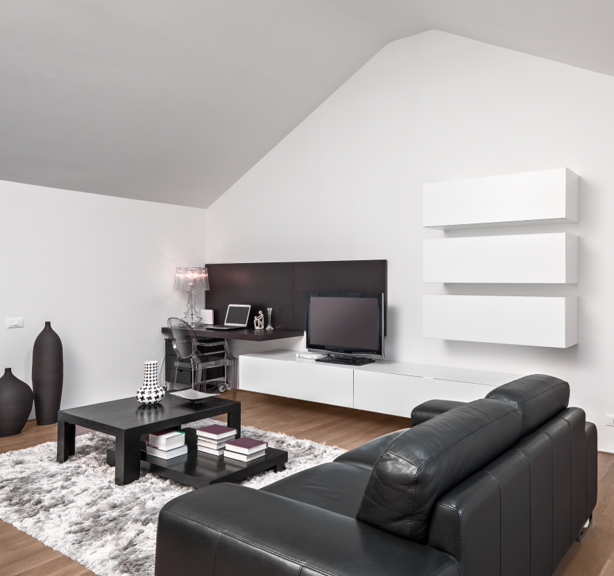Modern living room with black leather sofa, white walls, and floating shelves.