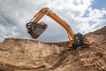 An excavator removing sand from a construction site