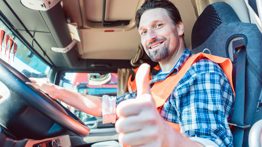 a man in an orange vest is giving a thumbs up