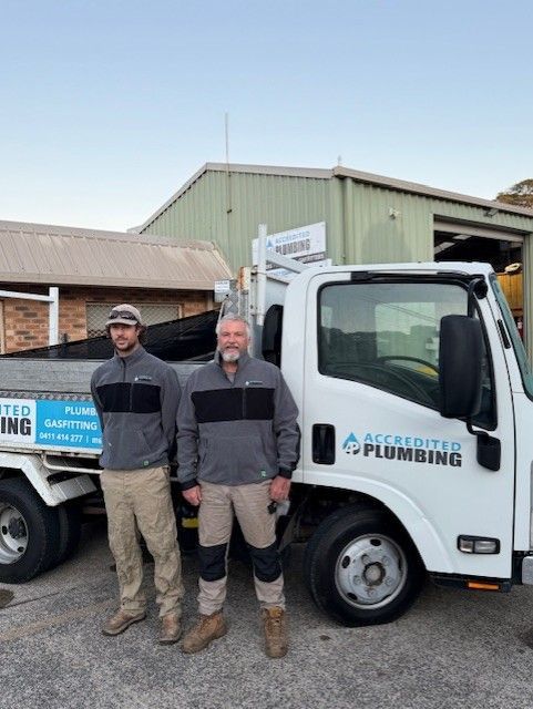 Two Men Are Standing In Front Of A Plumbing Truck — Accredited Plumbing in Ulladulla, NSW