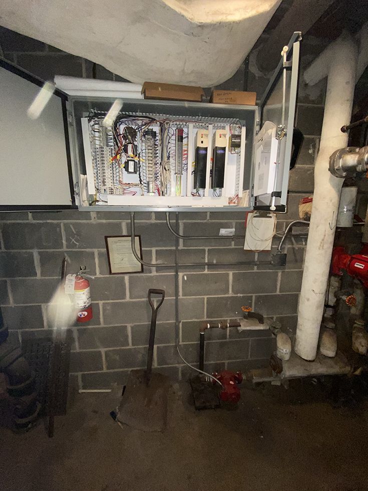 A brick wall with a box of electrical equipment on it.