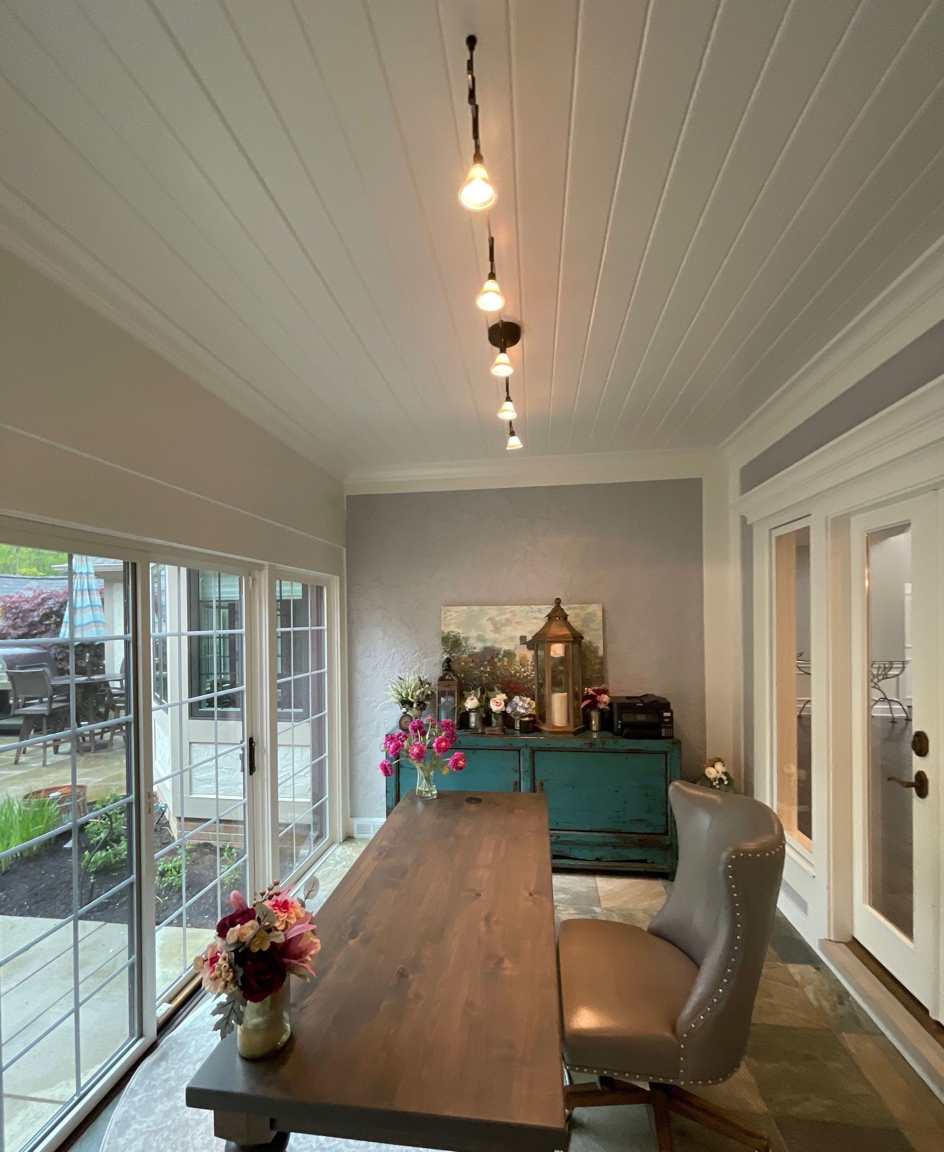 A room with a table and chairs and sliding glass doors