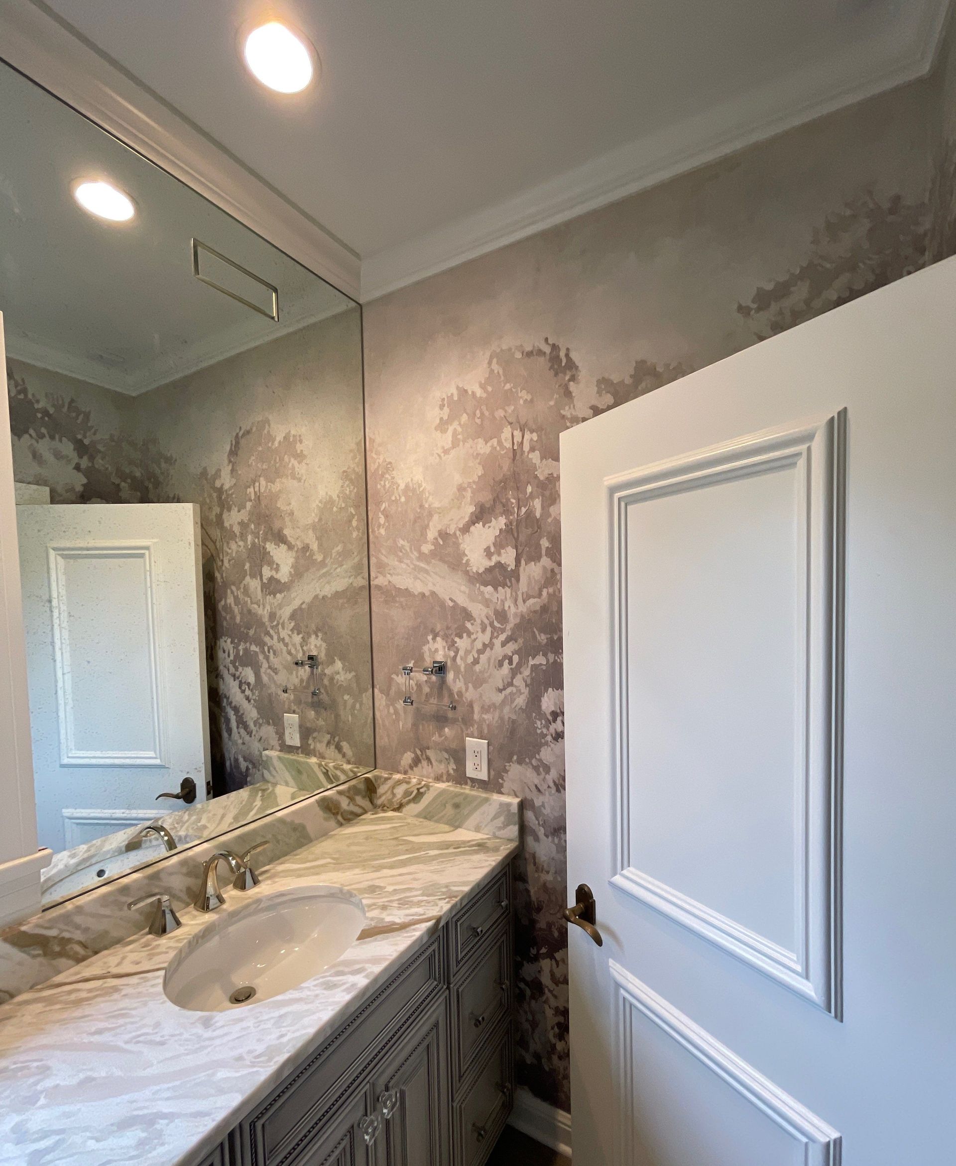 A bathroom with a sink and a large mirror