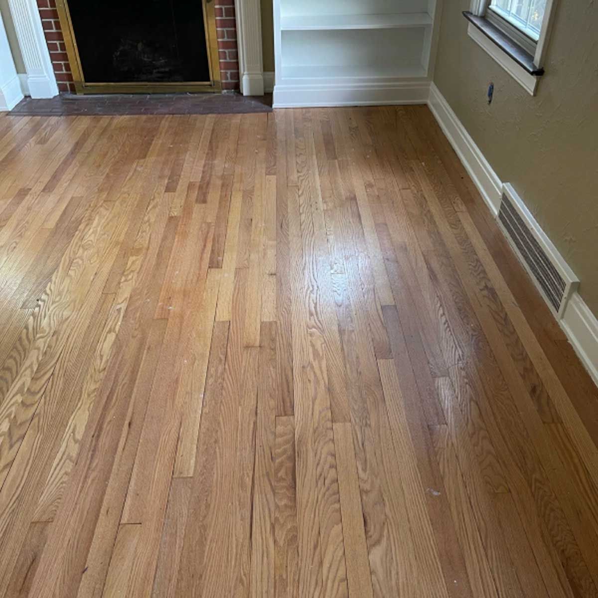A living room with hardwood floors and a fireplace.