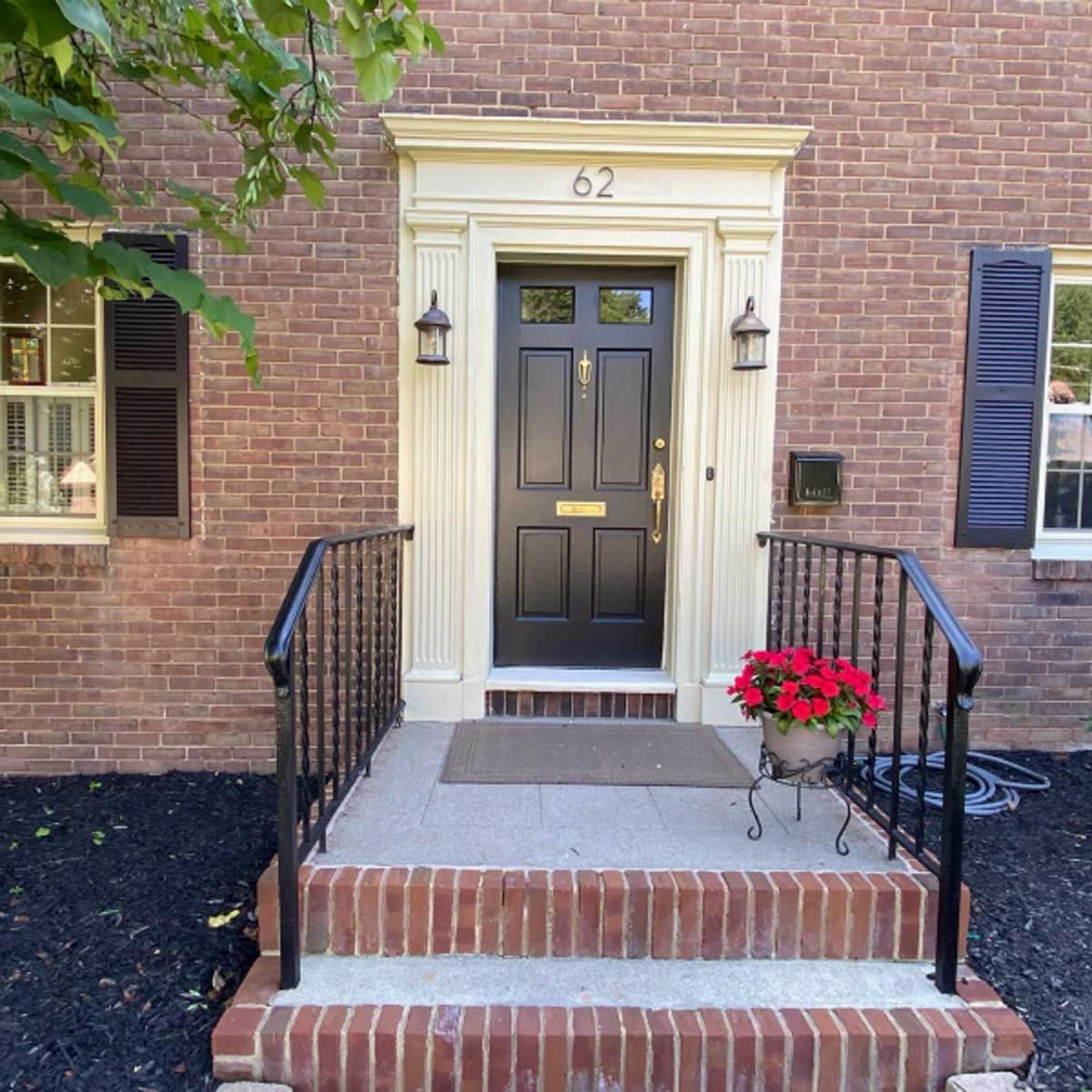 The front door of a brick house with the number 62 on it
