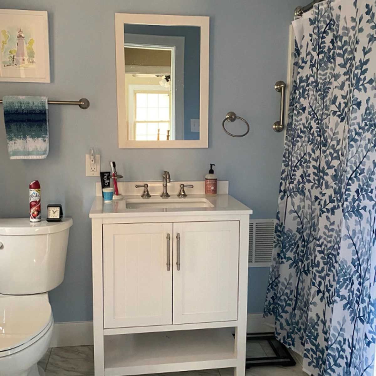 A bathroom with a toilet a sink and a mirror