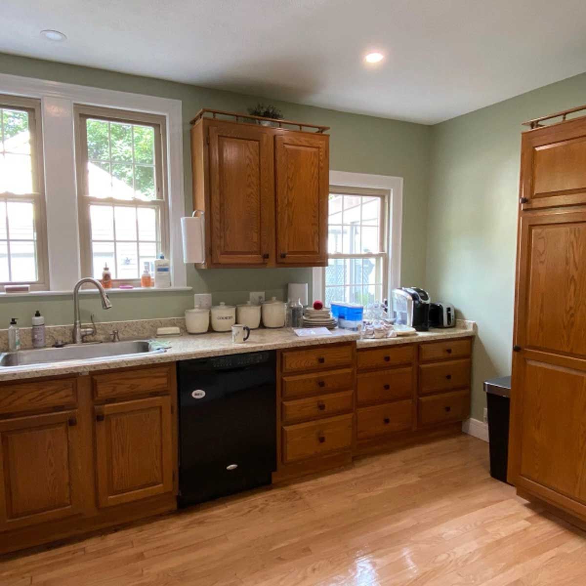A kitchen with wooden cabinets and a black dishwasher
