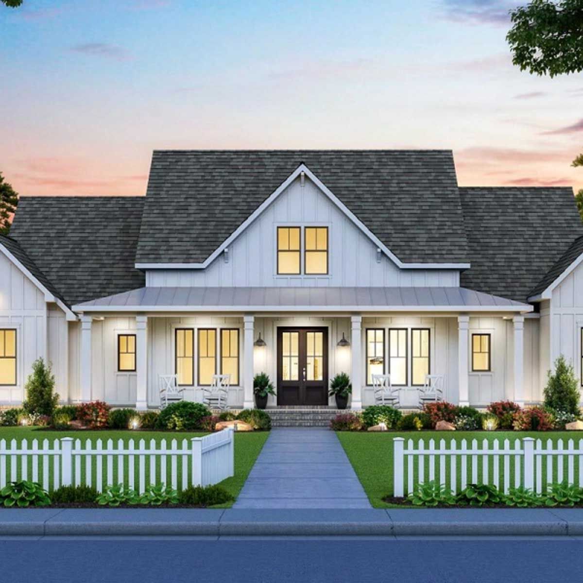 A large white house with a gray roof and a white picket fence.