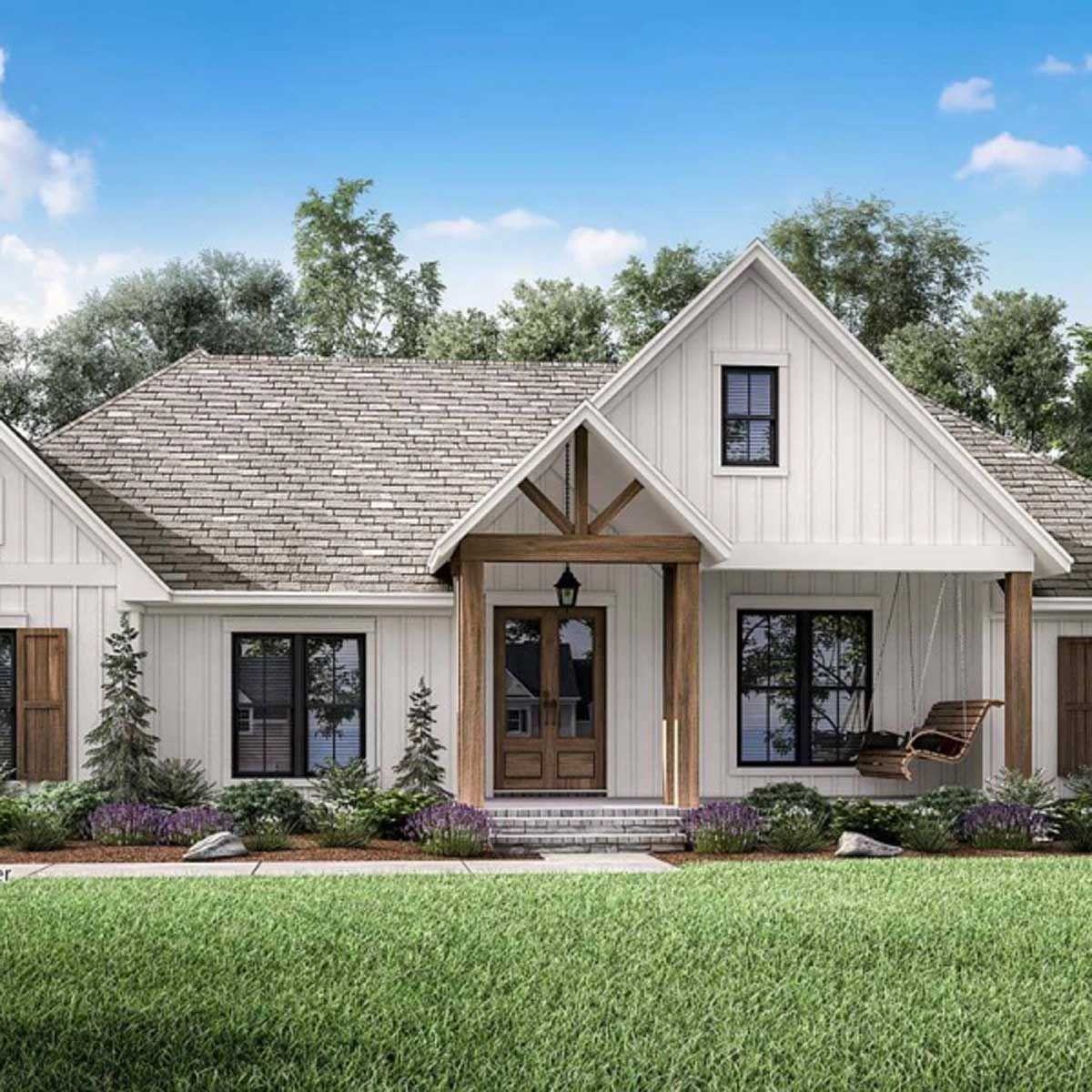 A white house with a gray roof is sitting on top of a lush green lawn.