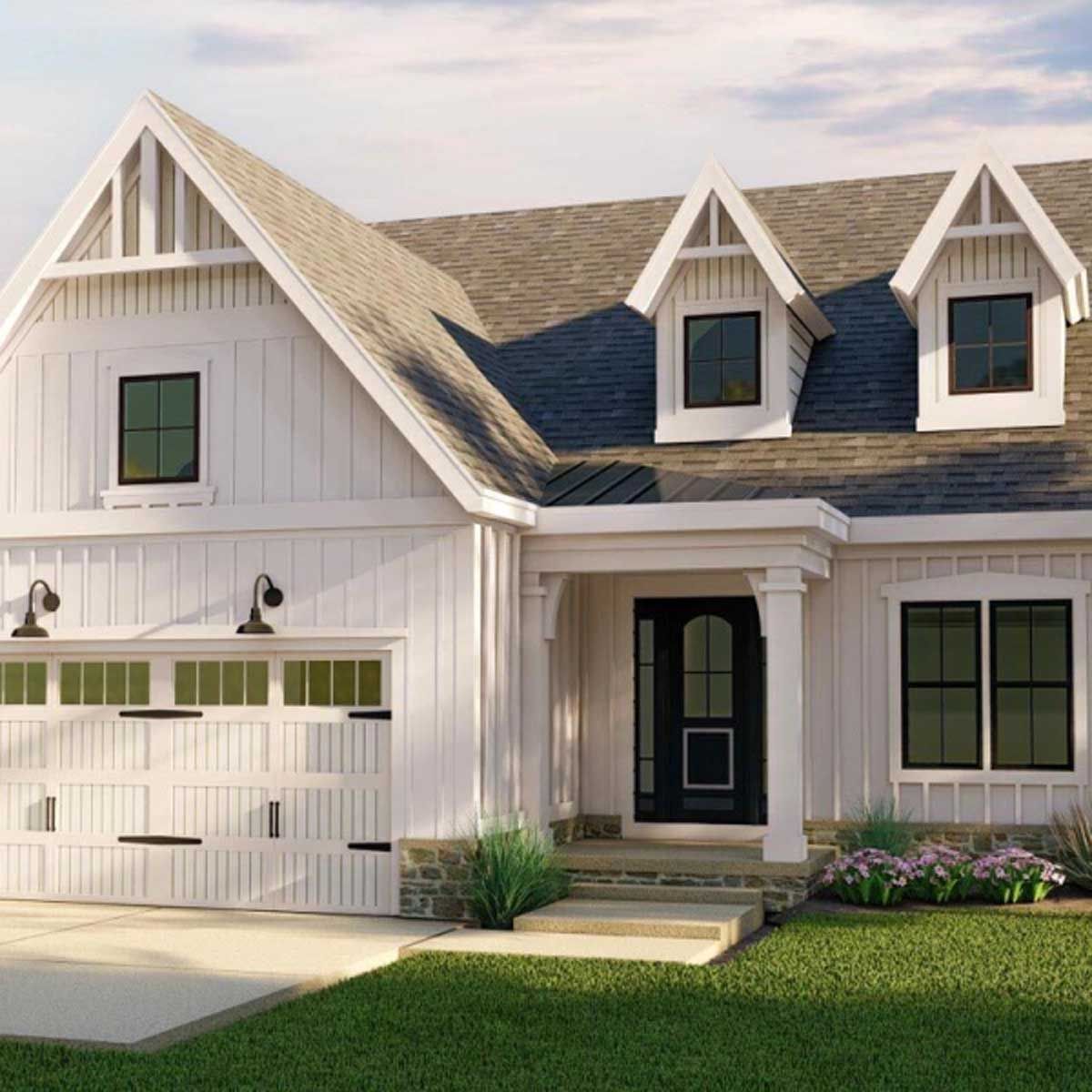 A white house with a brown roof and a black door