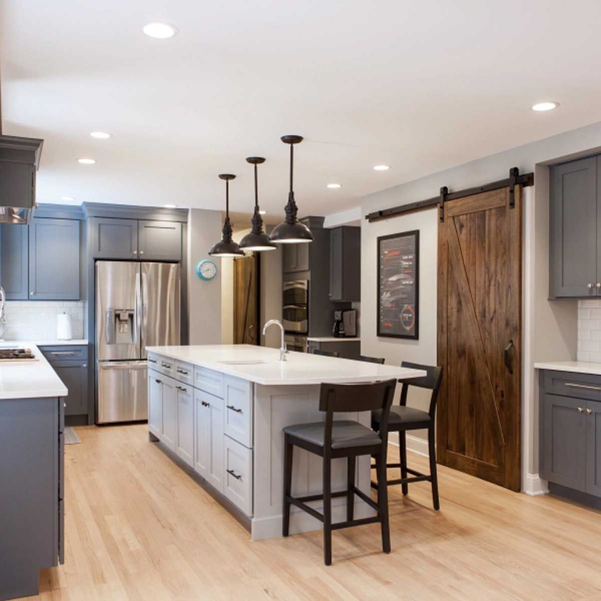 A kitchen with a large island and a sliding barn door