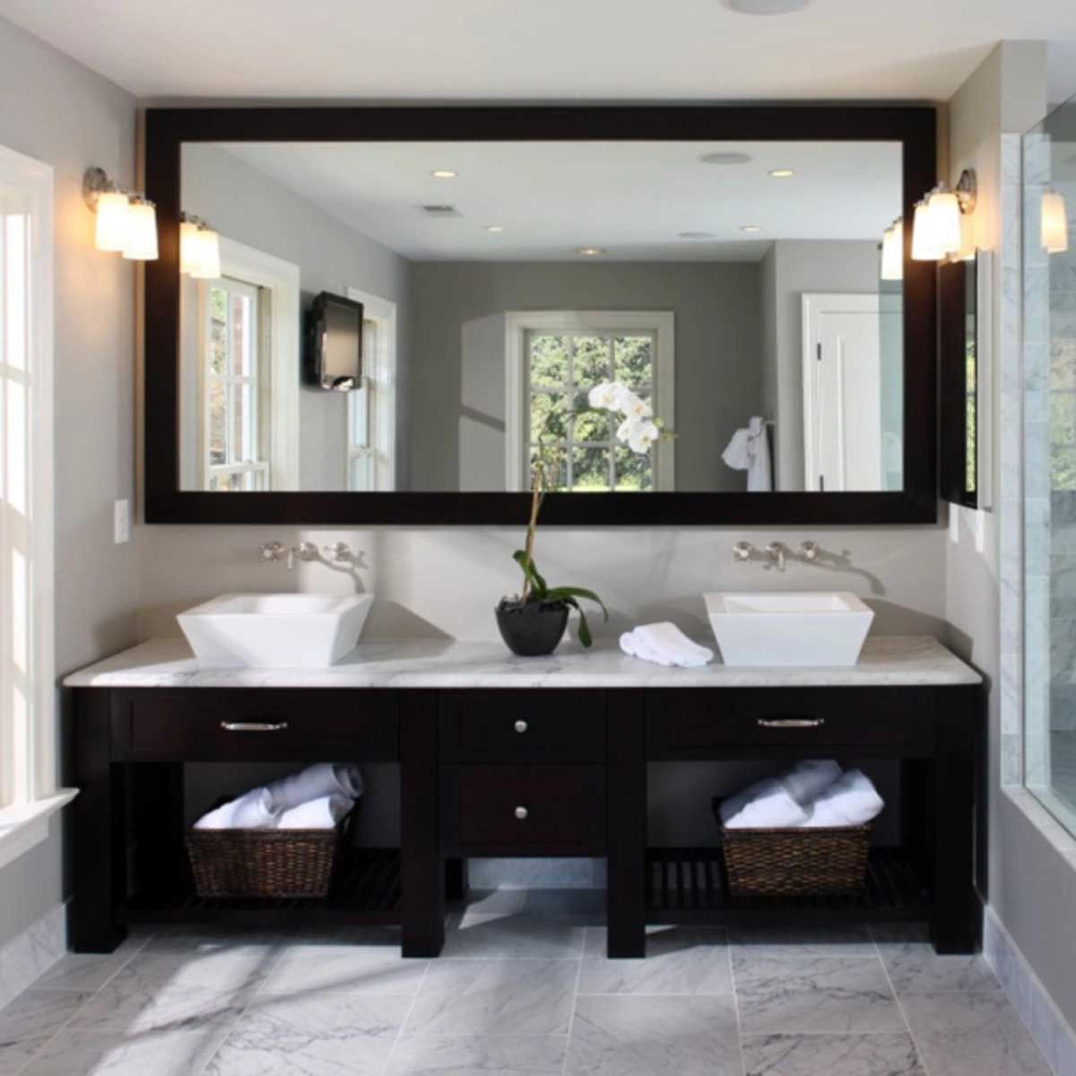 A bathroom with two sinks and a large mirror