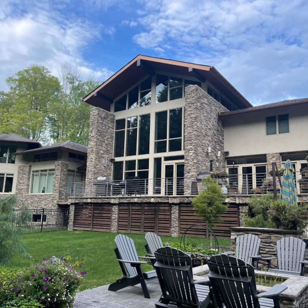 A large house with a lot of windows and chairs in front of it