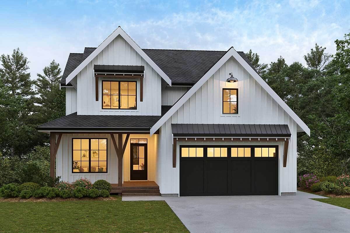 A white house with a black garage door and a black roof.