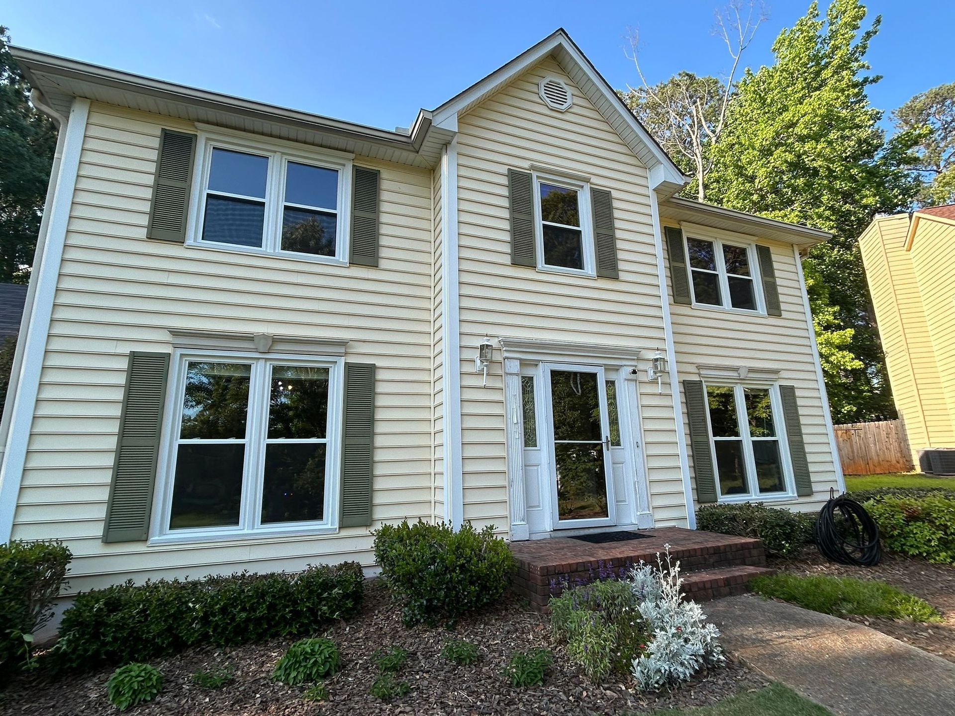 A large white house with a lot of windows and shutters.