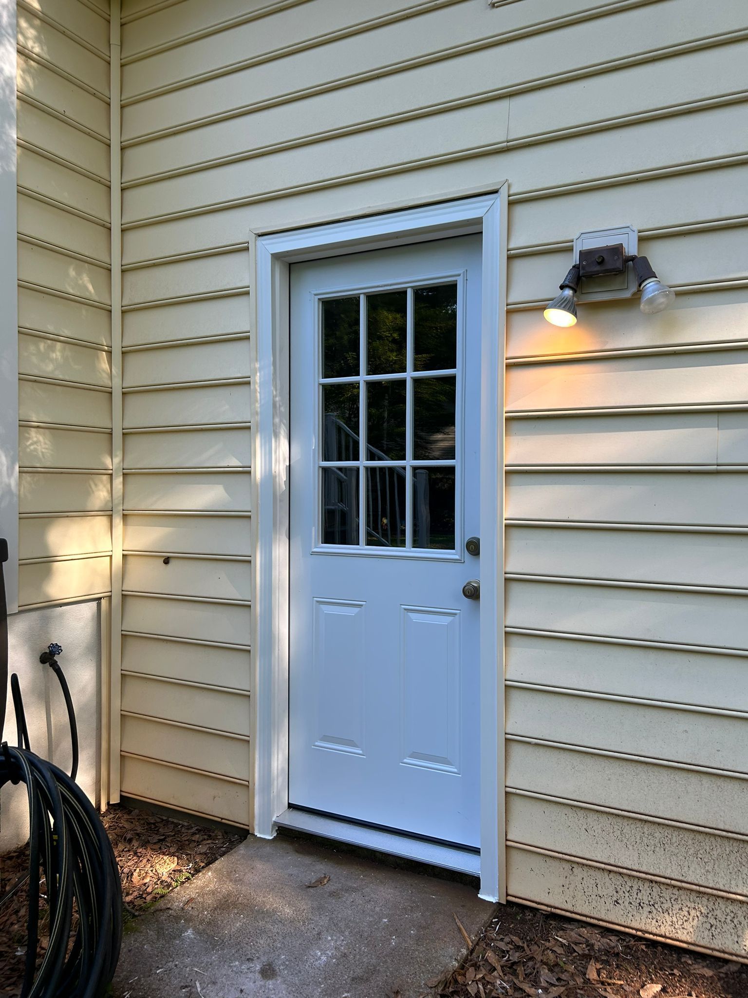 A white door is on the side of a house.