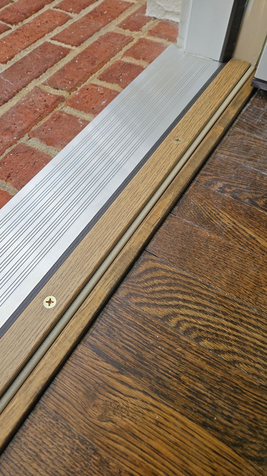 A close up of a wooden floor next to a sliding glass door.