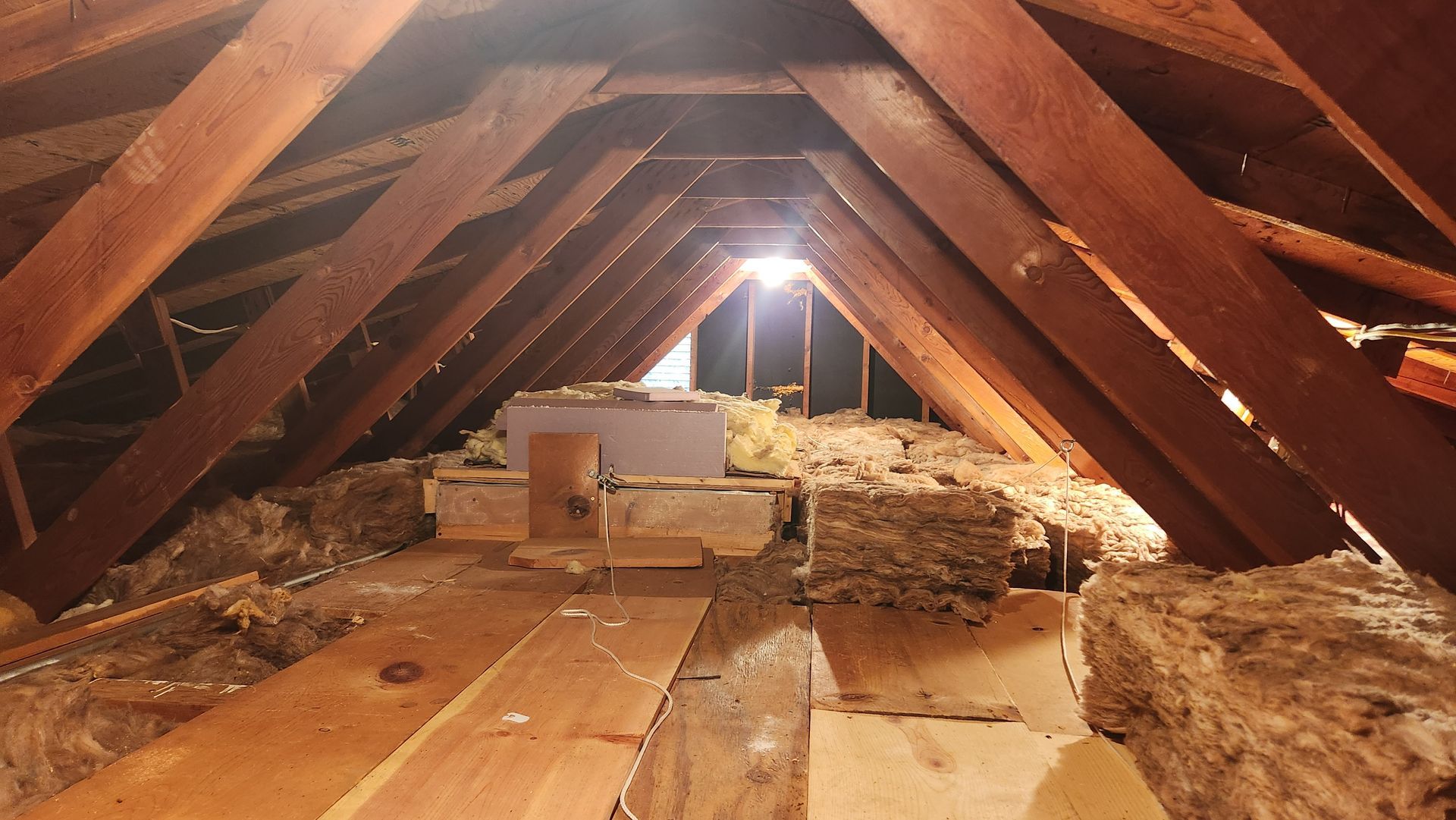 An attic with a lot of wooden beams and a door.