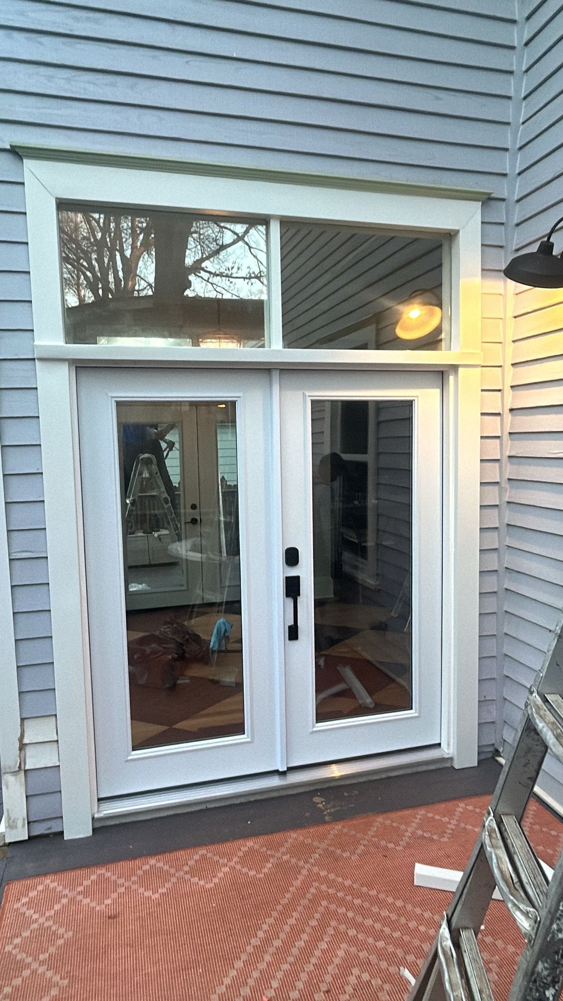 A white sliding glass door with a window on the side of a house.