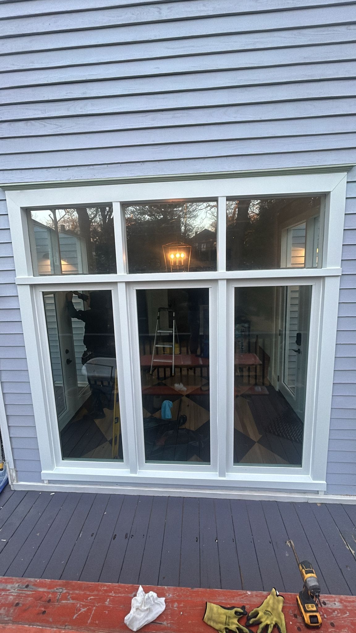 A sliding glass door is being installed on the side of a house.