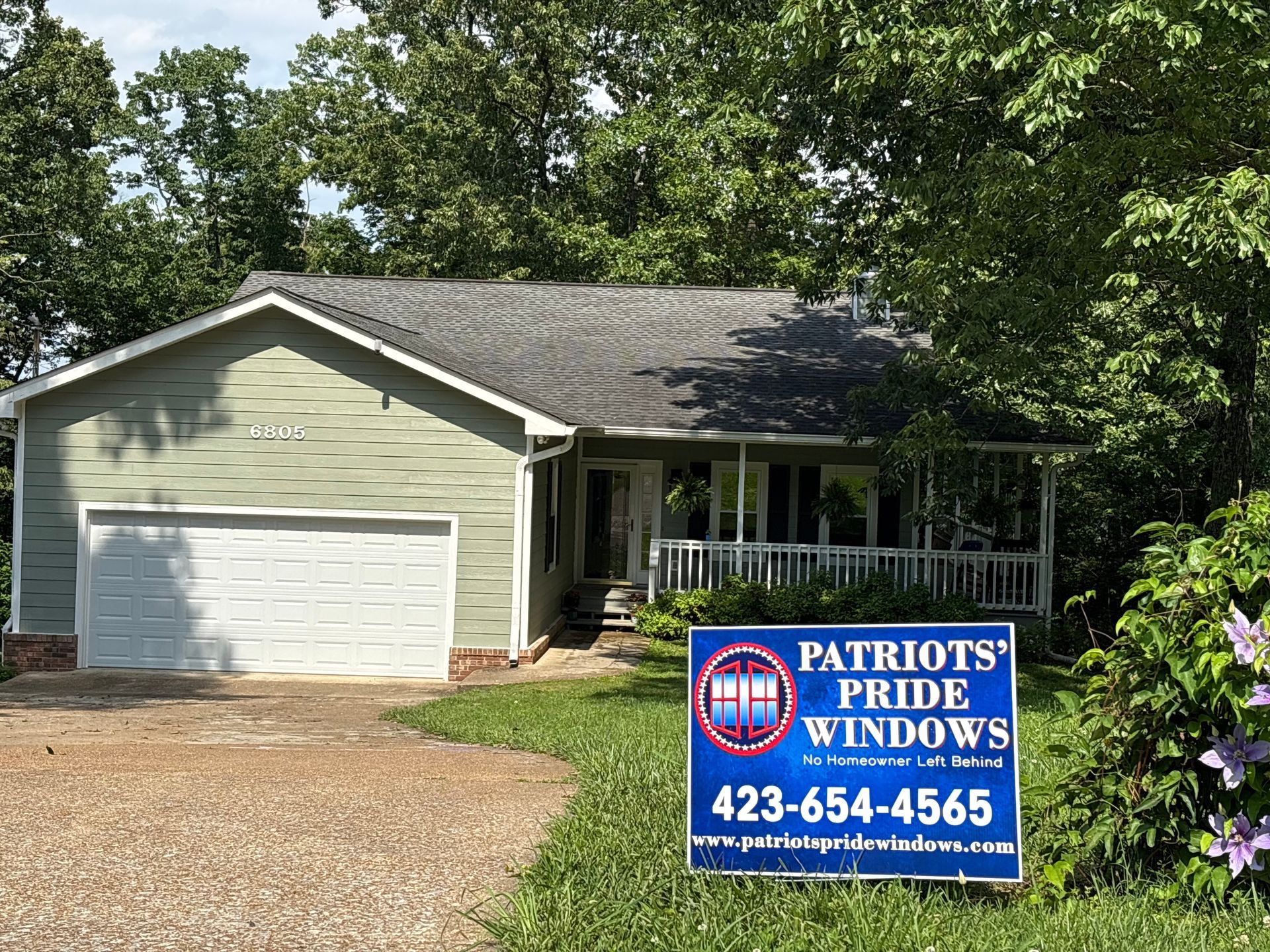 A house with a sign in front of it that says `` patriots pride windows ''.