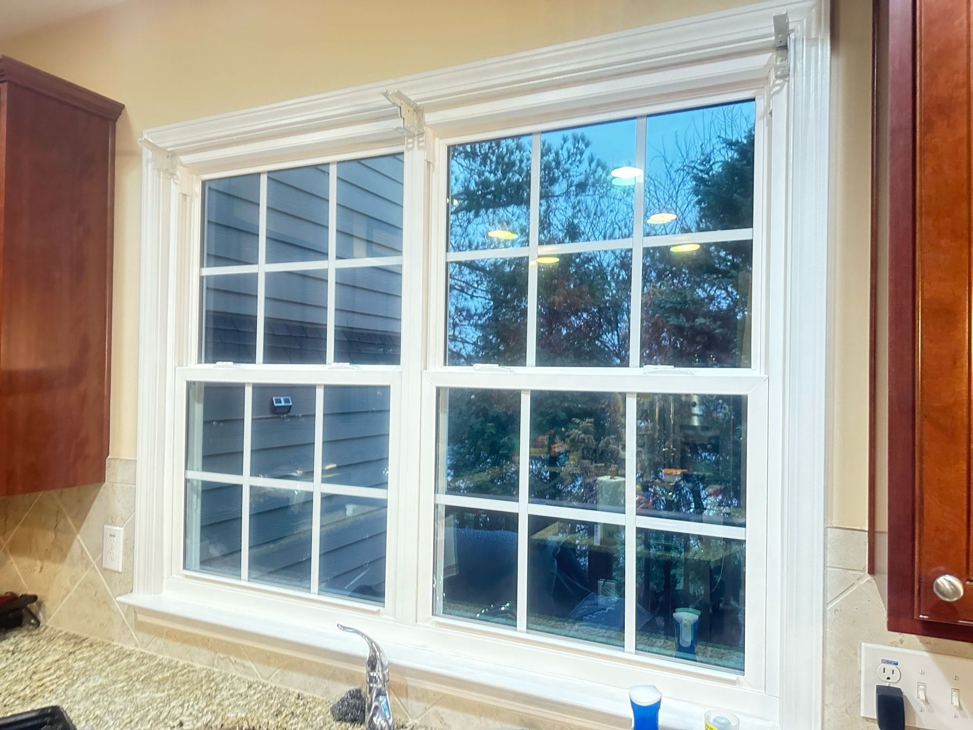 A kitchen with two windows and a sink.