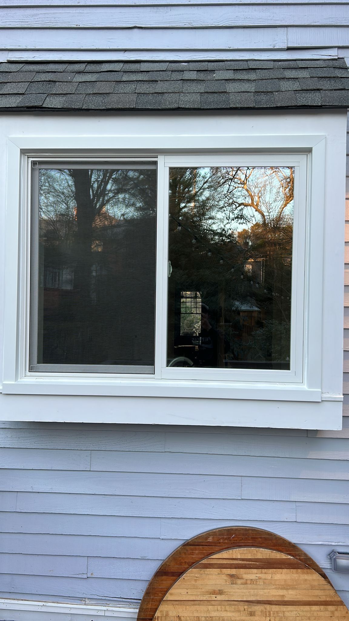 A white window is on the side of a house.