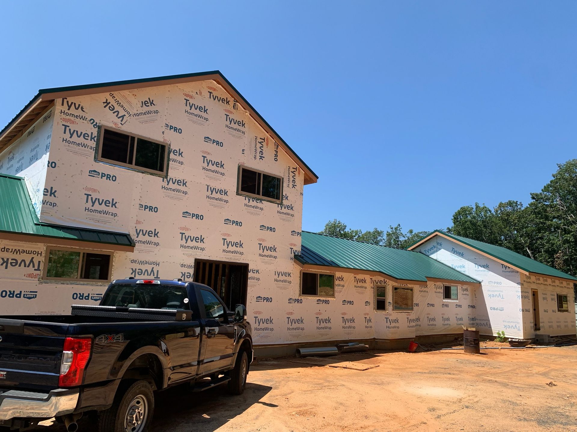 A truck is parked in front of a building under construction.