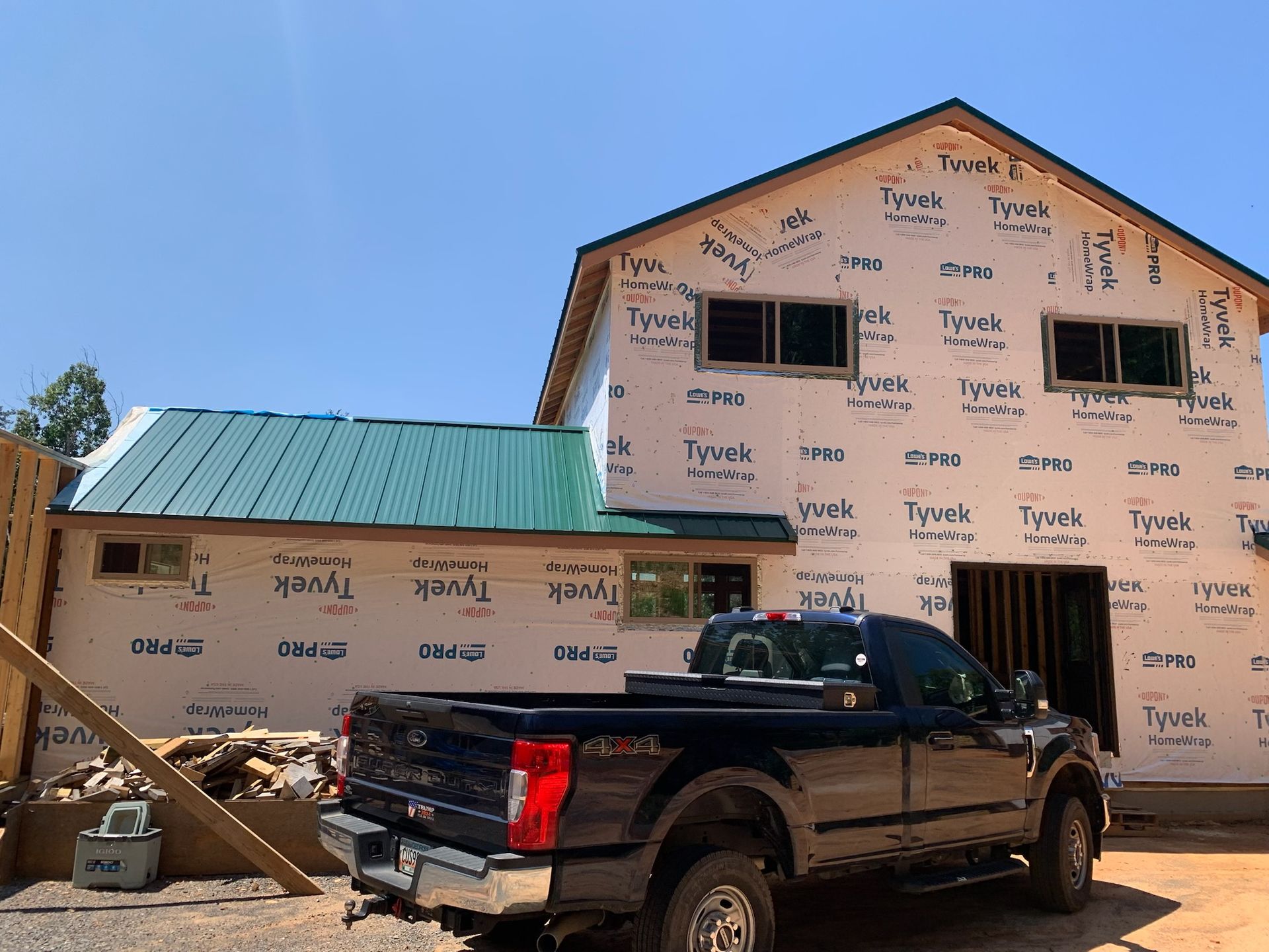 A black truck is parked in front of a building under construction