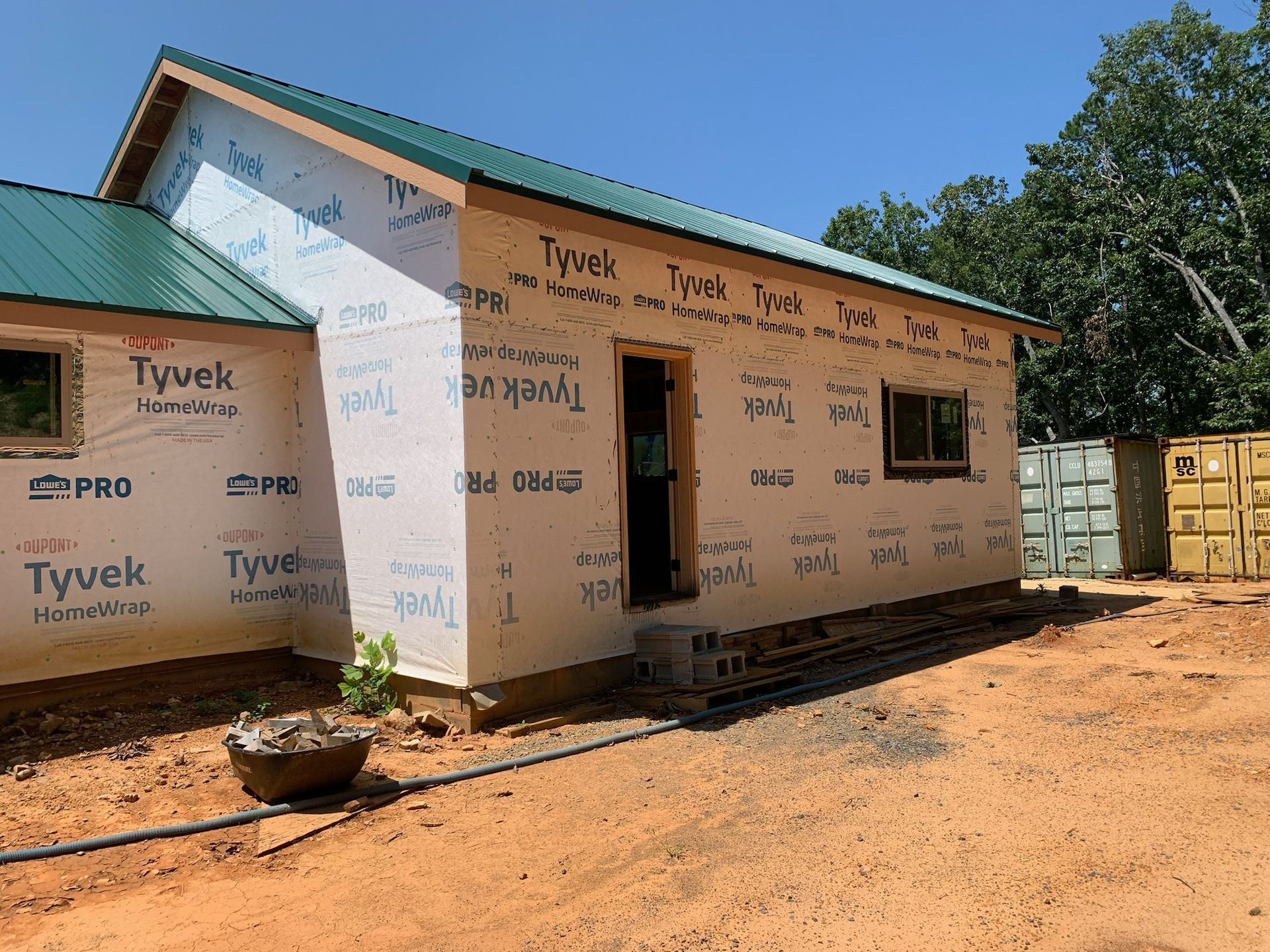 A house with a green roof is being built.