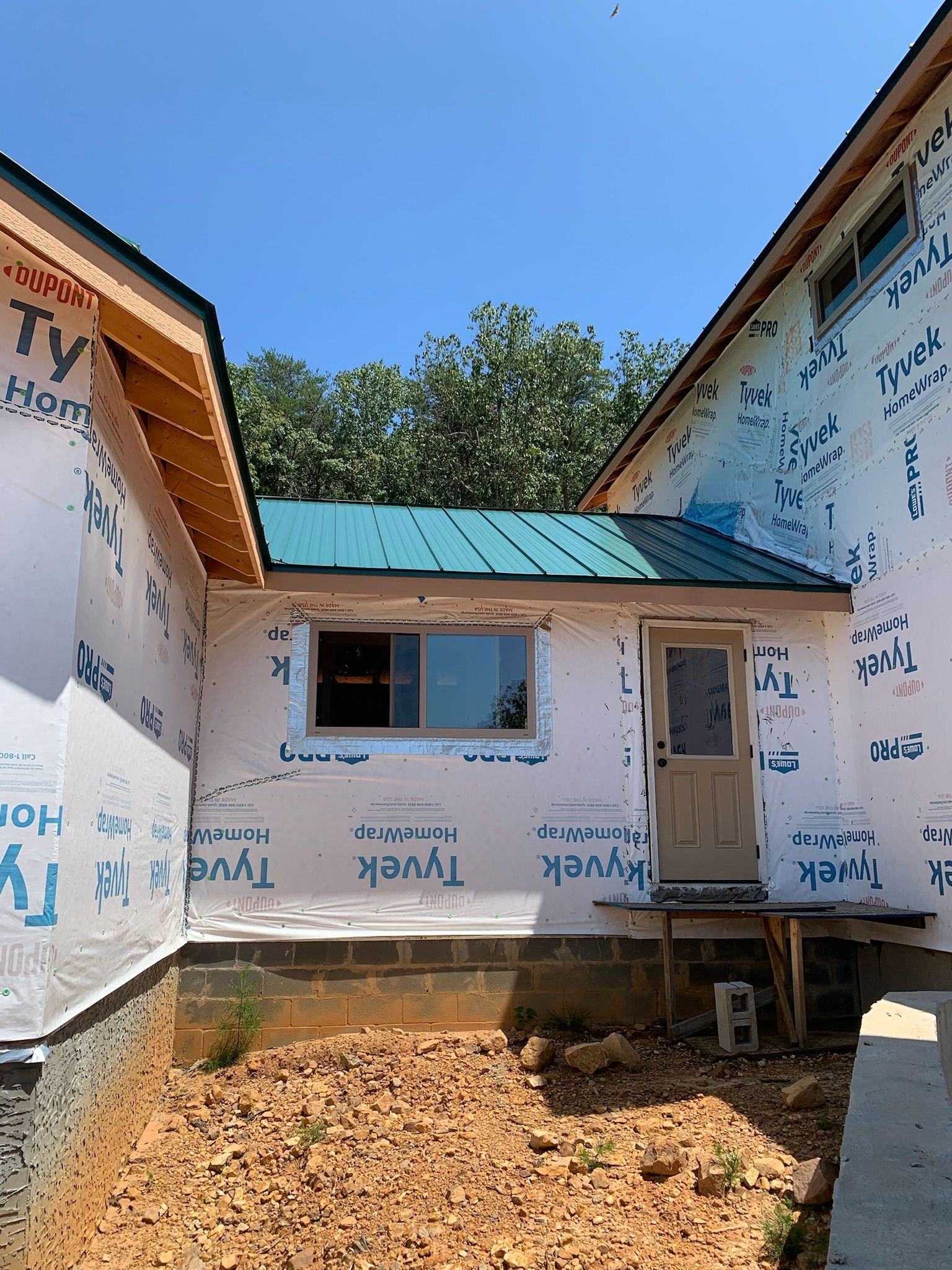 A house with a green roof is being built.