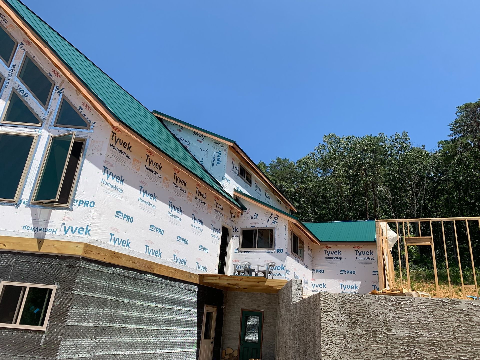 A large house with a green roof is being built.