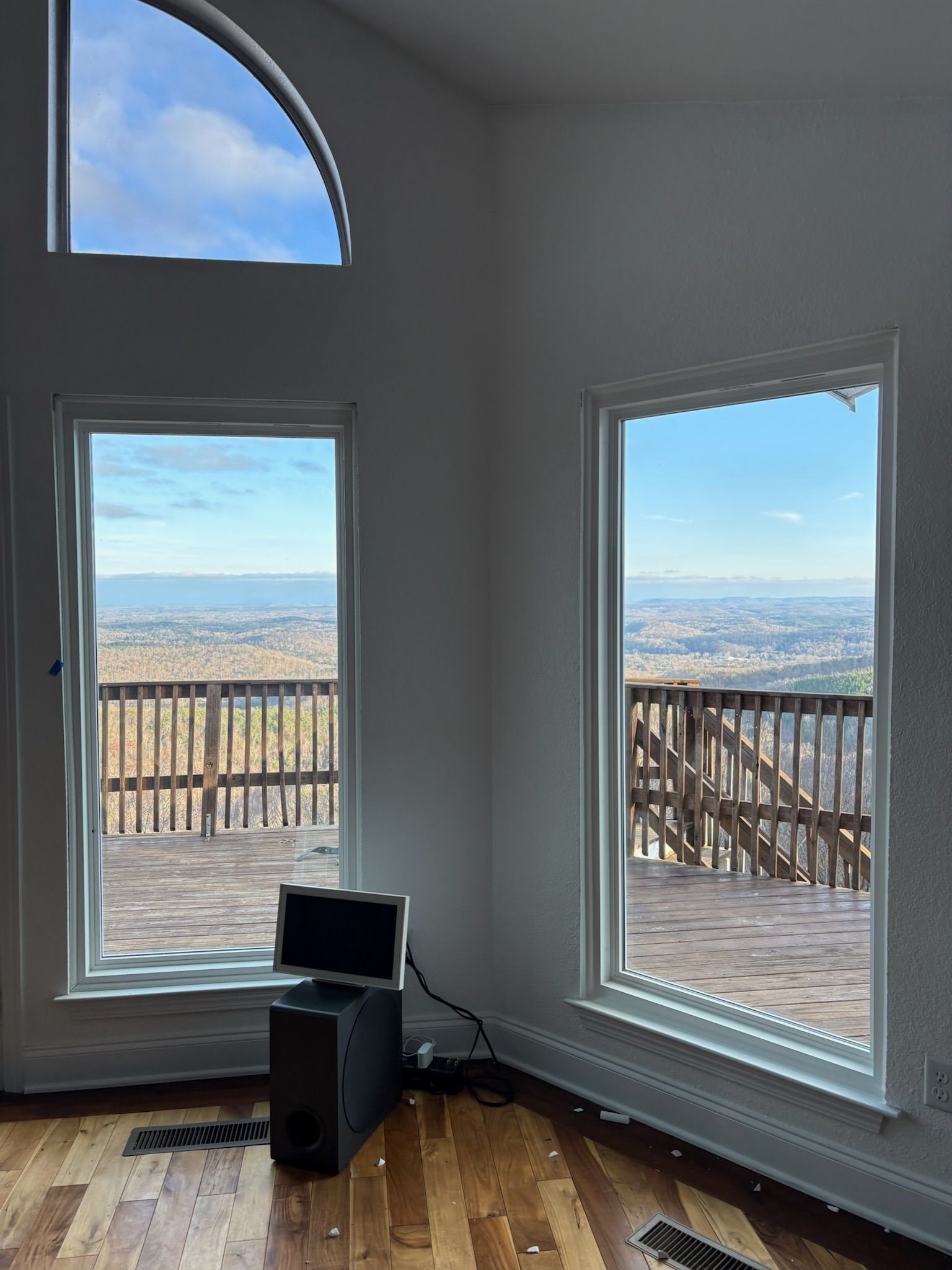 A room with a lot of windows and a laptop on the floor