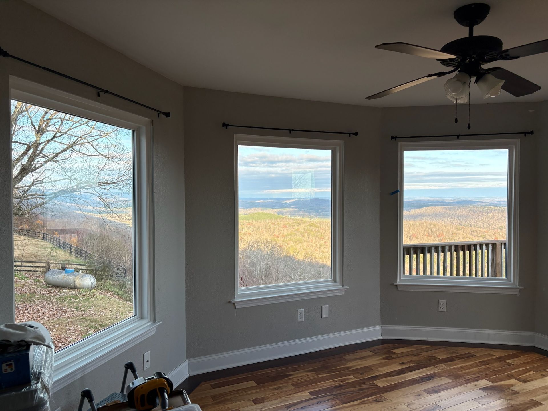 A room with a lot of windows and a ceiling fan.