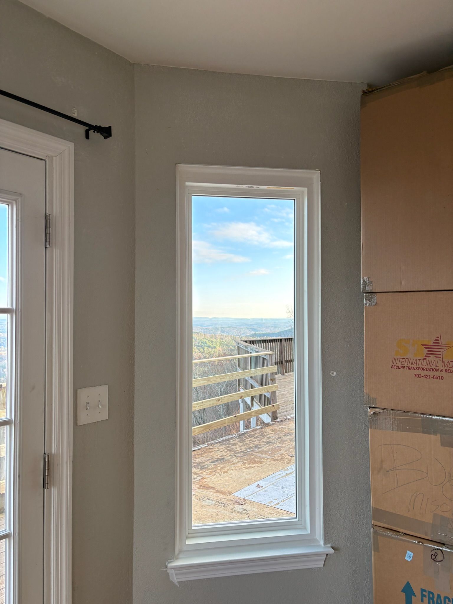 A room with a window and boxes on the wall.