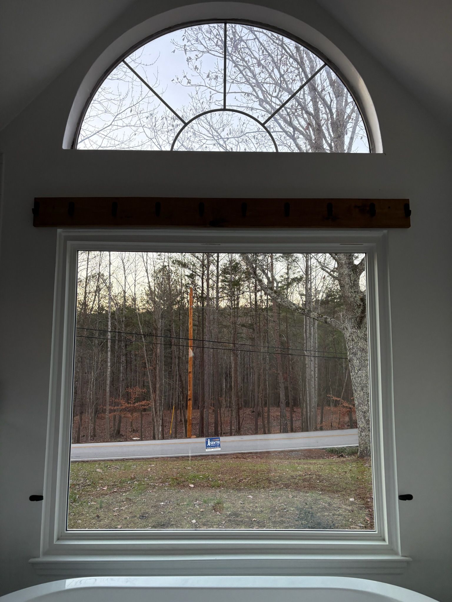 A window with a view of a forest and a road