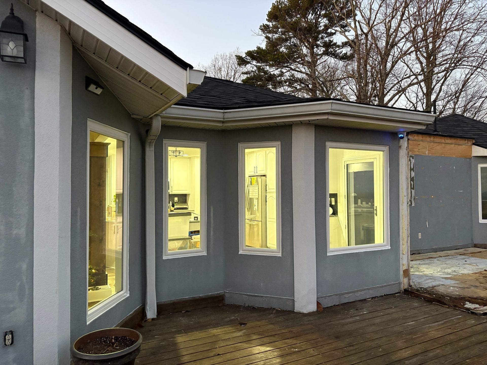 A house with a lot of windows and a wooden deck.