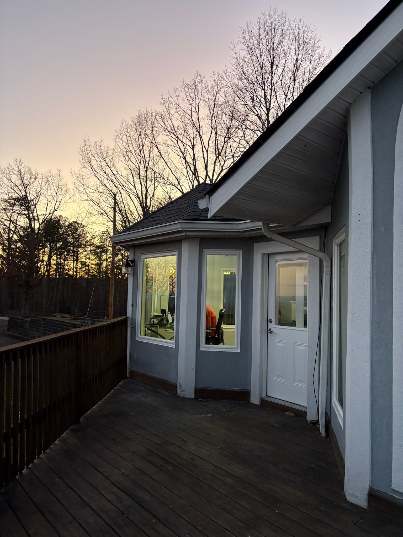 A house with a deck and a sunset in the background