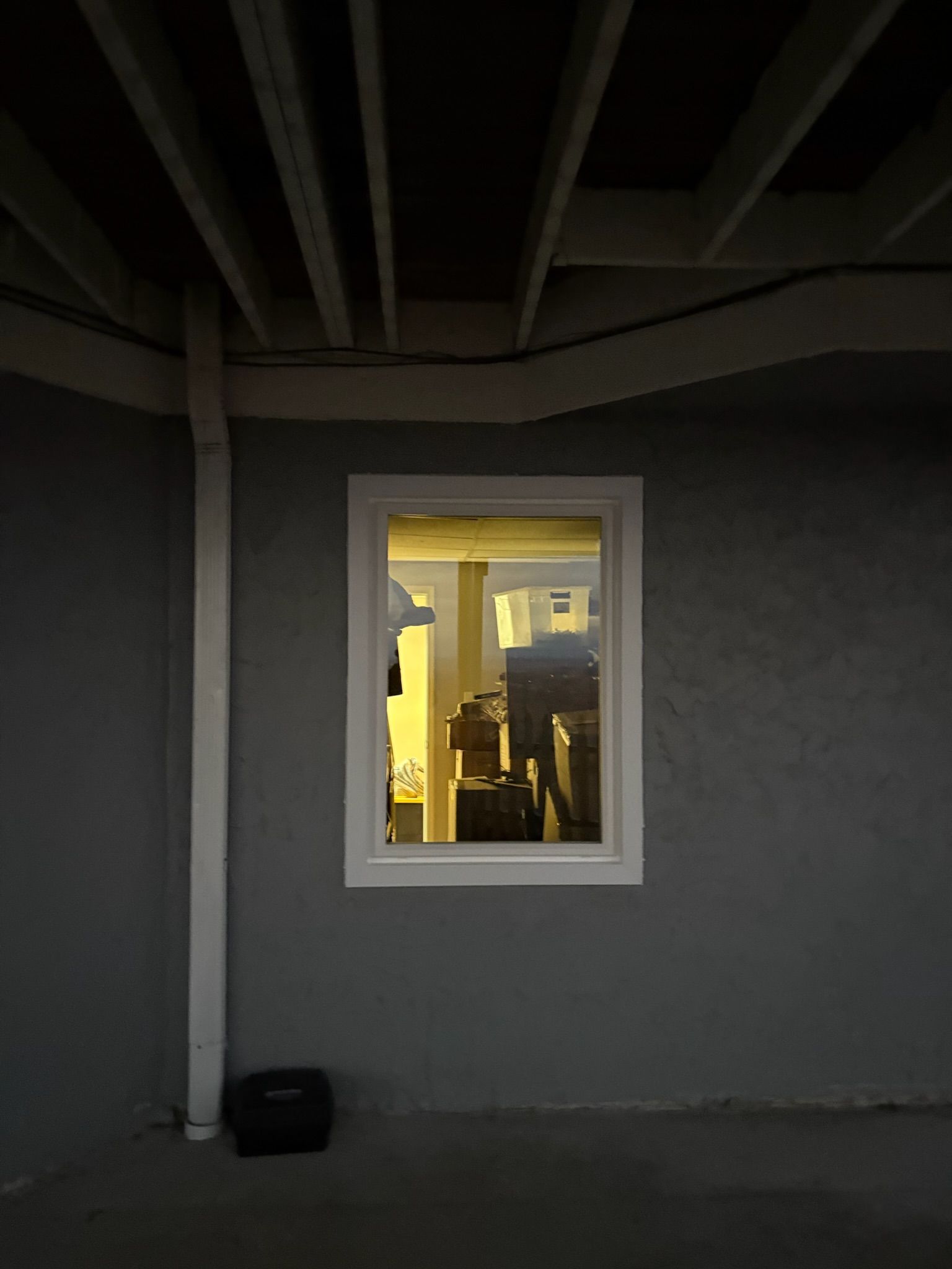 A window on the side of a building with a reflection of a building in it.