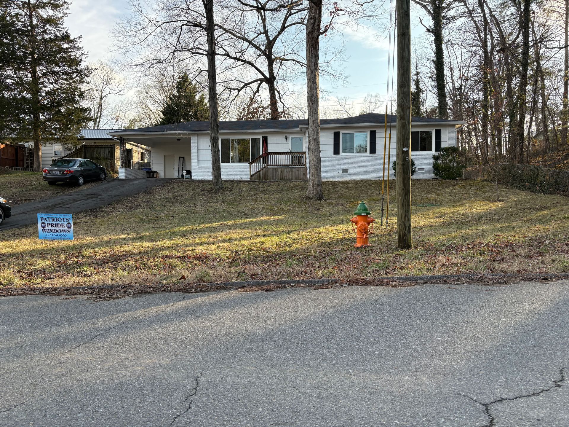A white house with a fire hydrant in front of it is for sale.