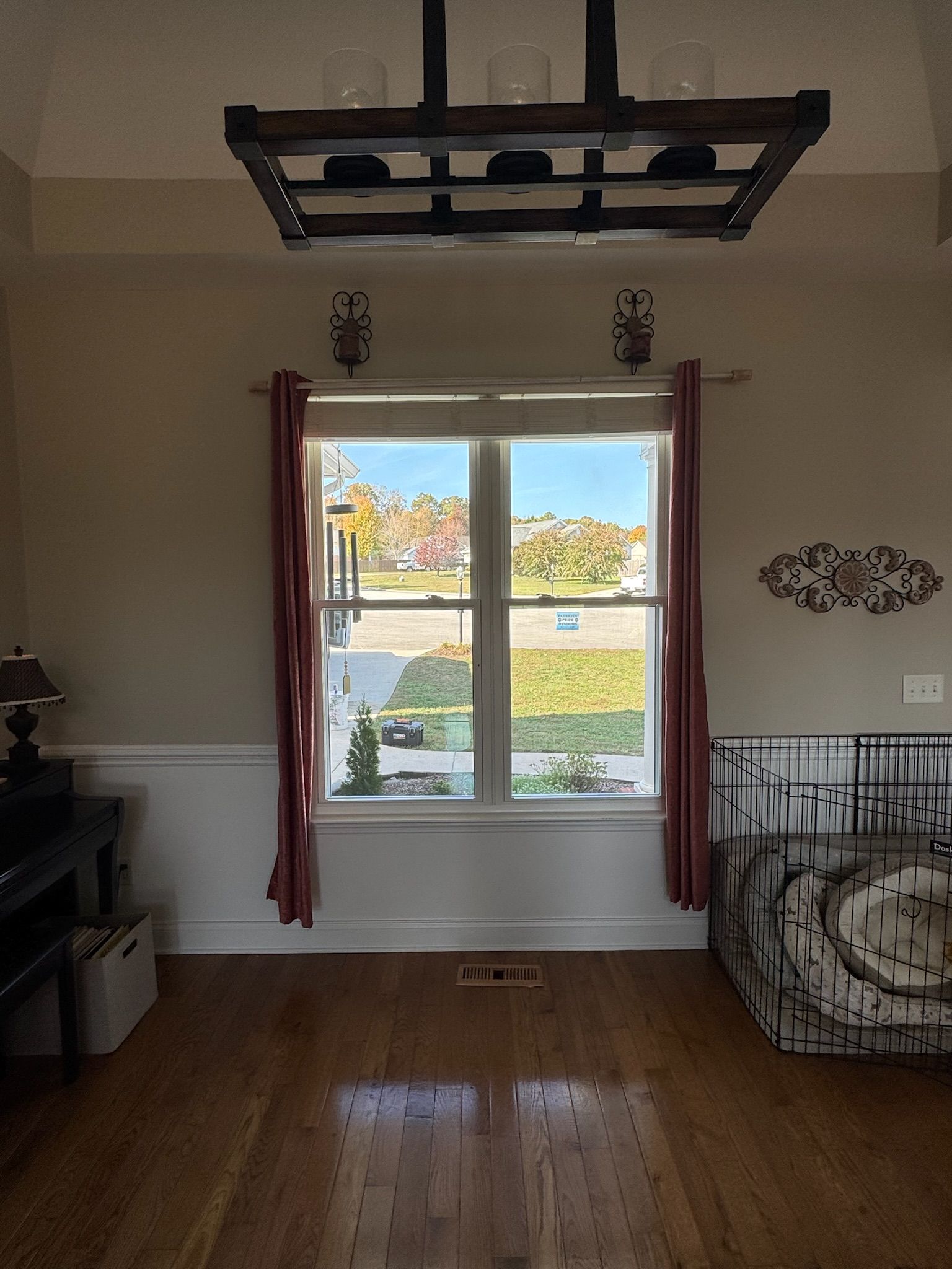 A living room with hardwood floors and a large window