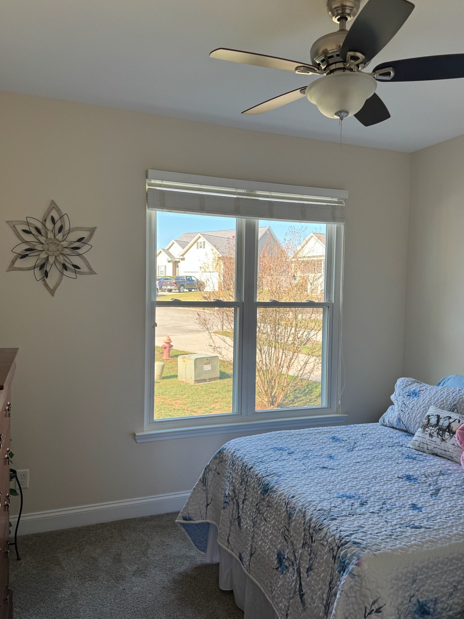 A bedroom with a bed , ceiling fan , and window.