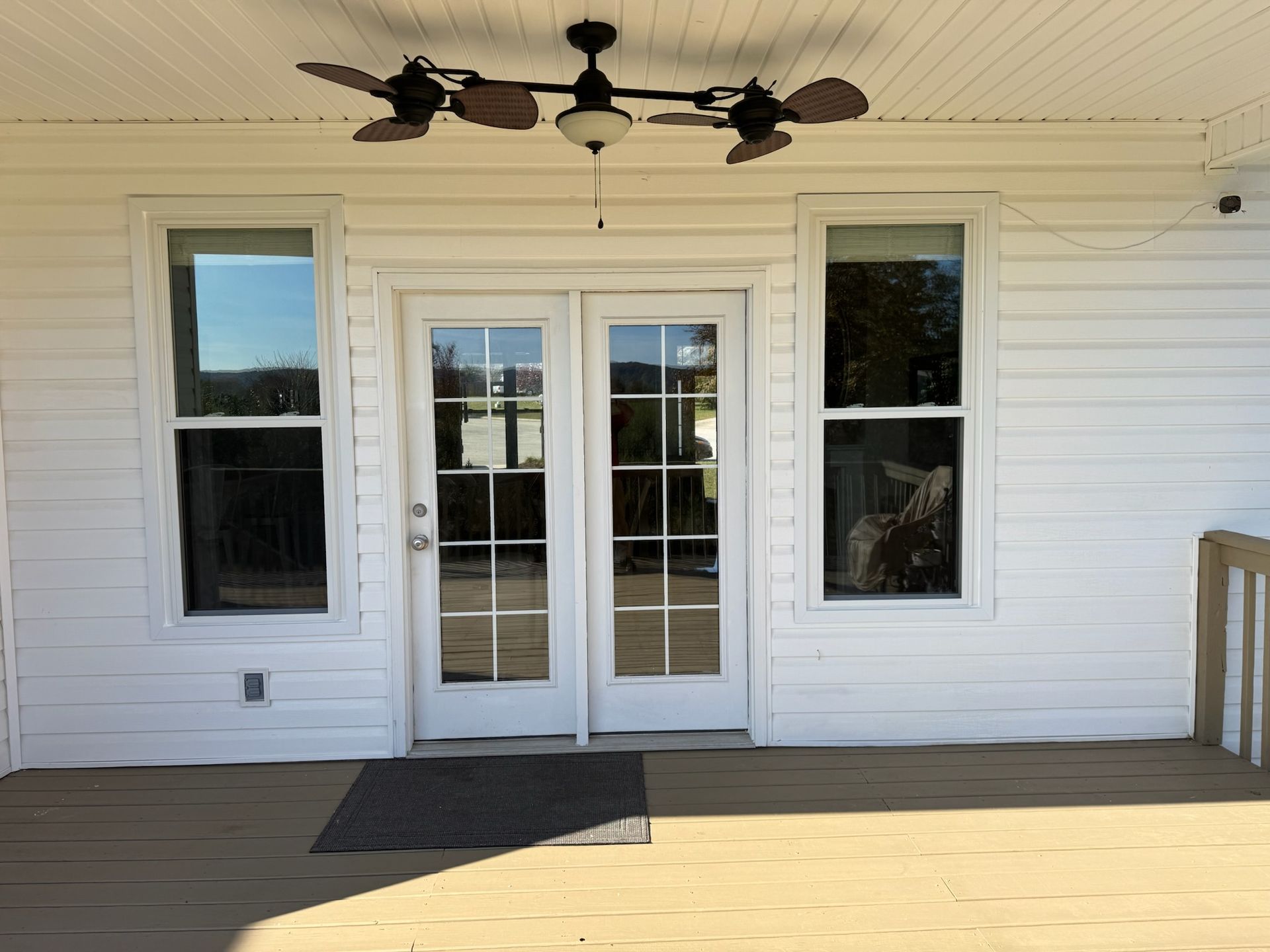 A white house with sliding glass doors and a ceiling fan