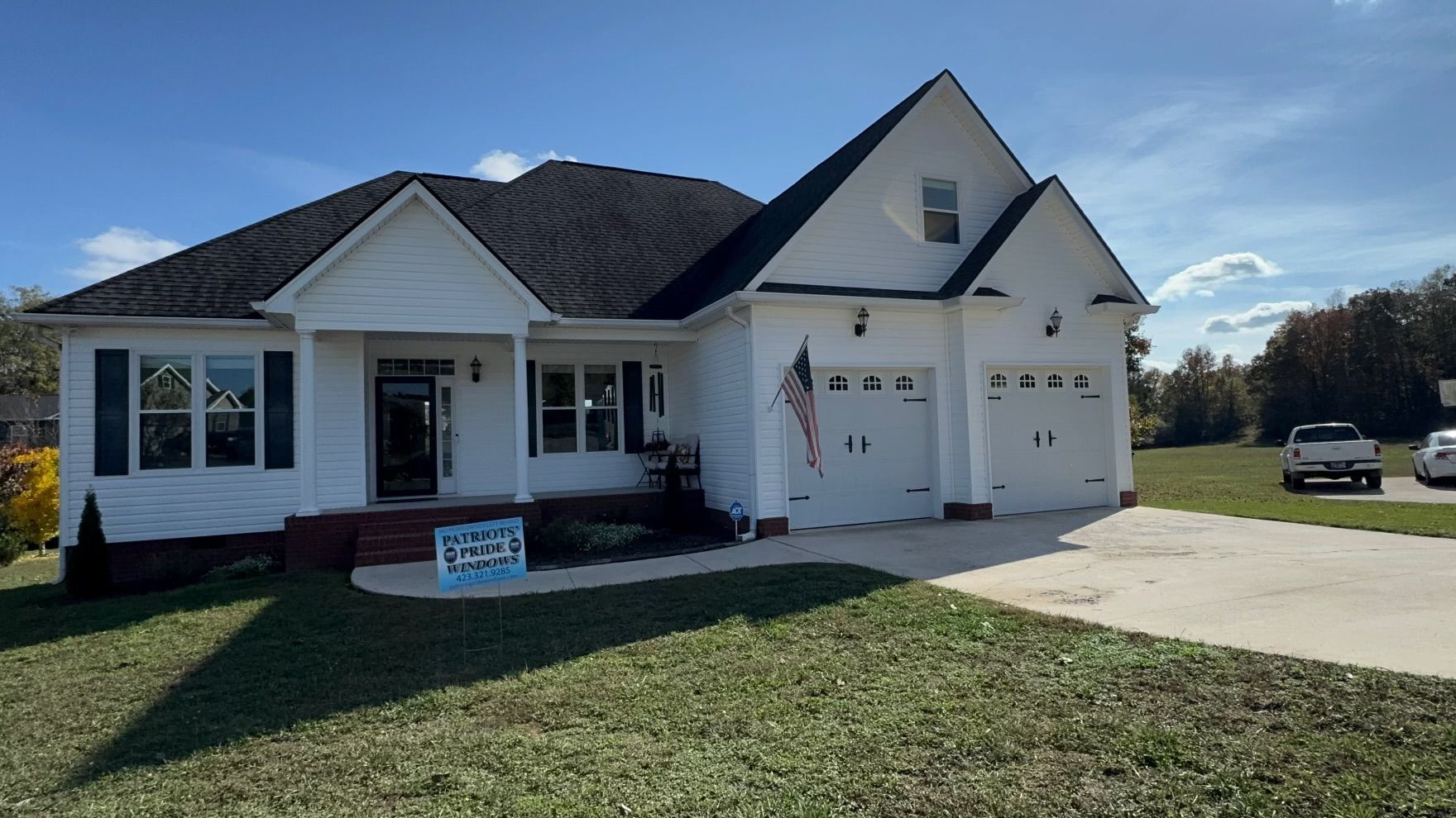 A white house with a black roof is for sale