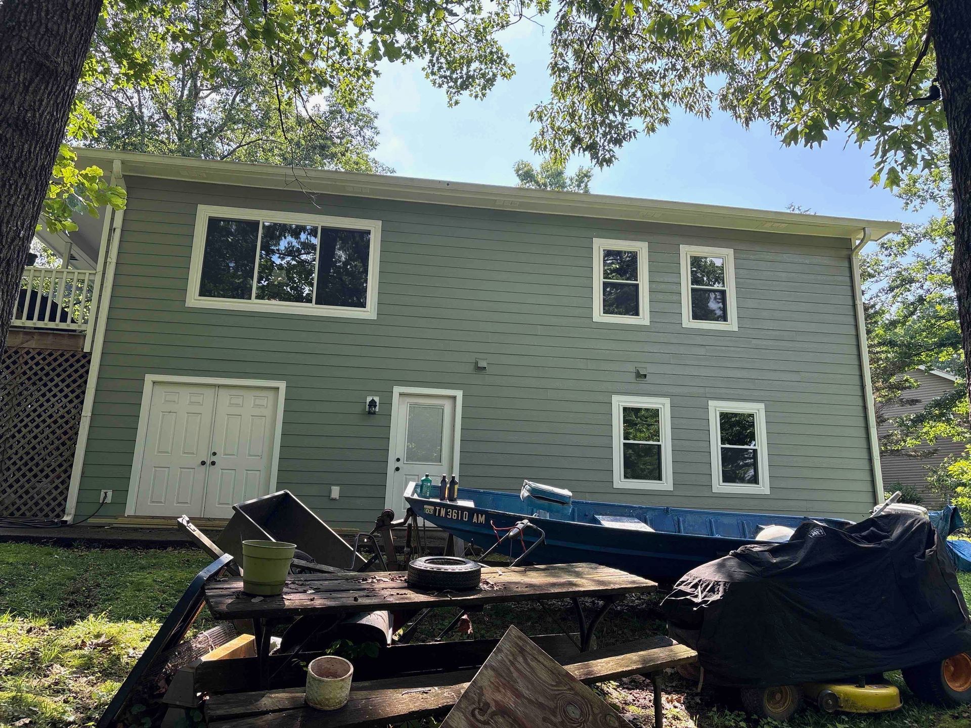A large house with a lot of windows and a picnic table in front of it.