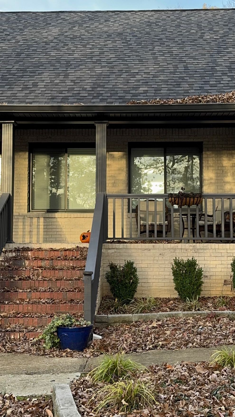 A brick house with a porch and stairs leading up to it.