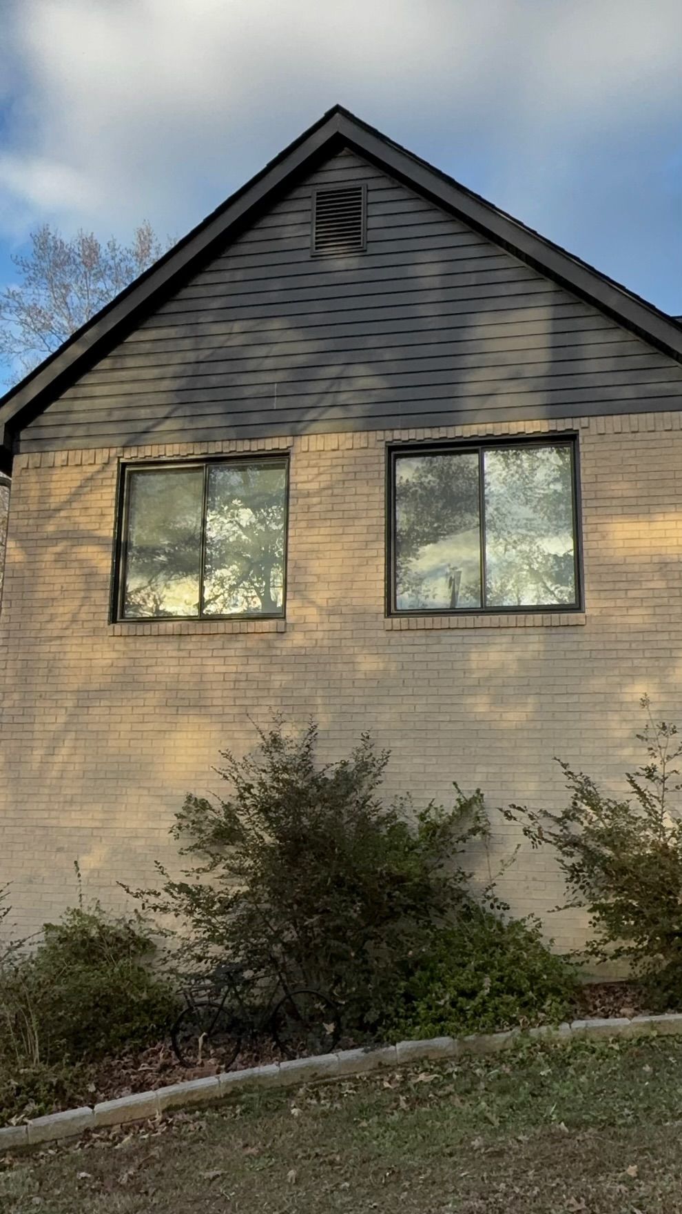 A house with two windows on the side of it.