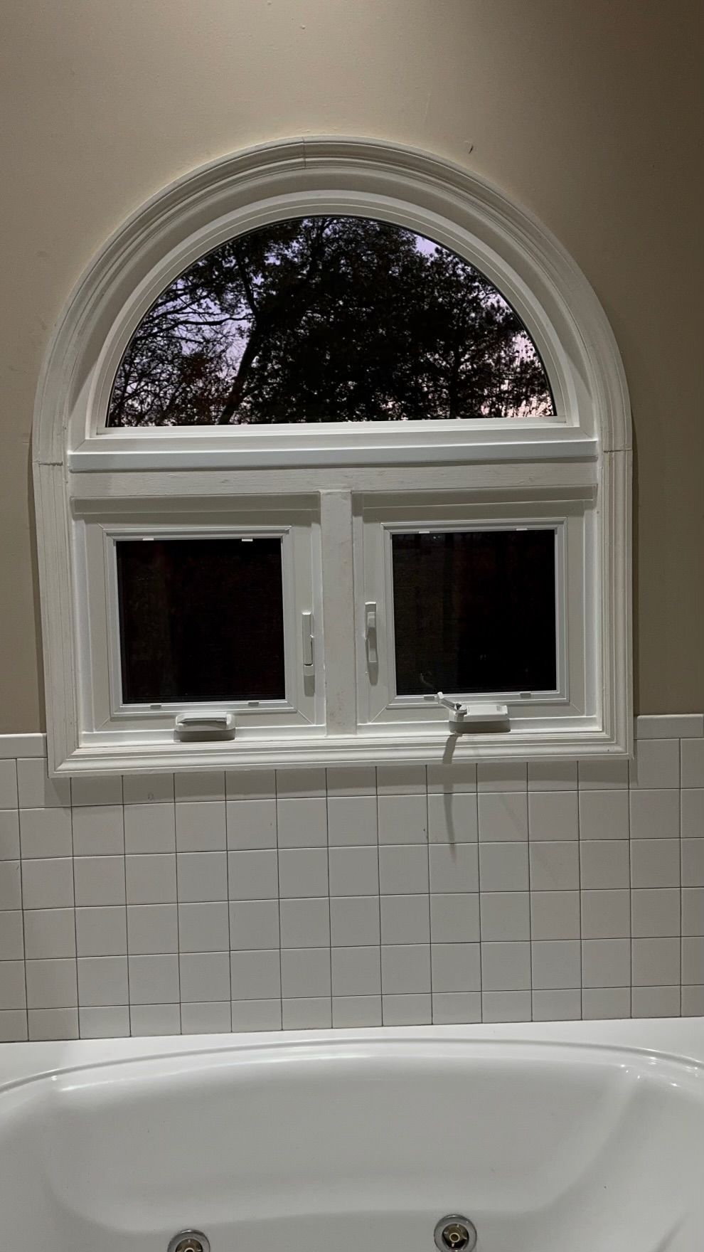 A bathroom with a bathtub and a window.