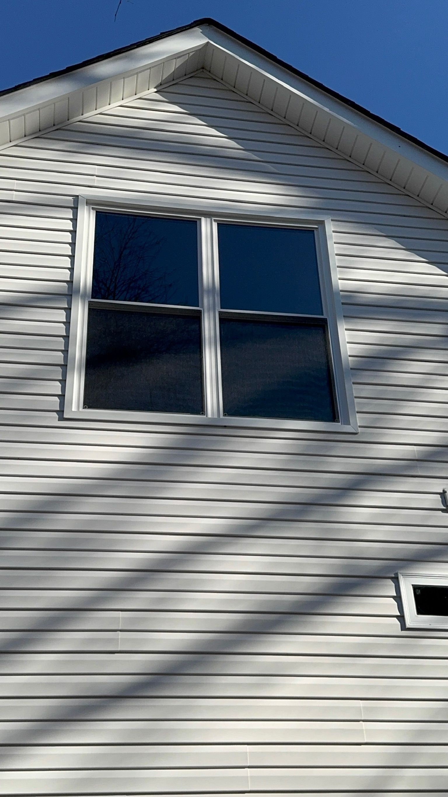 A white house with a window on the side of it.