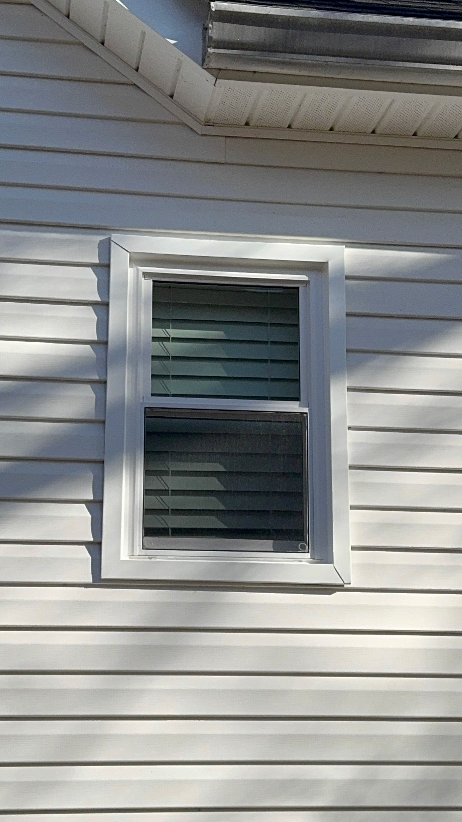 A white house with a window on the side of it.